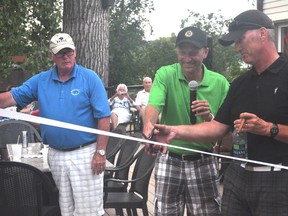 Preston Meier, Portage Golf Club president, and Duane Davison cut a ribbon to officially unveil the new deck at the Portage Golf Club following the Randy Davison Memorial Golf Tournament Aug. 15. (Kevin Hirschfield/The Graphic)