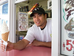 Tien Tran holds a soft serve ice cream cone at Merla Mae's Ice Cream on Adelaide Street in London, Ontario on Friday August 15, 2014.  Cooler than usual summer weather has impacted the frozen treat business, leaving the shop empty at times when lines would normally stretch out the door. (CRAIG GLOVER, The London Free Press)