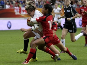 Canada's wing Magali Harvey tackles England's flanker Marlie Packer during the IRB Women's Rugby World Cup final match between England and Canada at the Jean Bouin Stadium in Paris on August 17, 2014. AFP PHOTO / KENZO TRIBOUILLARD