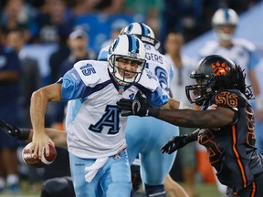 Arognauts' Ricky Ray looks to flee a Lions defender on Sunday night at the Rogers Centre. (STAN BEHAL/TORONTO SUN)