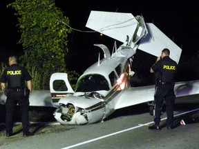OPP investigators look at the wreckage of downed six-passenger civilain aircraft. The pilot was the only one in the plane and was taken to Trenton Memorial Hospital. Reports from the scene say the pilot avoided a crash landing in the Bay of Quinte just a few metres to the south. The crash occurred shortly after 9 p.m. Sunday, August. 17, 2014 in Trenton, Ont. A section of the Loyalist Parkway (Hwy. 33) remains closed. Transportation safety board inspectors were on their way to the scene Sunday. Ernst Kuglin/The Intelligencer/QMI Agency