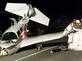 Fire Department investigators look at the wreckage of downed six-passenger civilain aircraft. The pilot was the only one in the plane and was taken to Trenton Memorial Hospital. Reports from the scene say the pilot avoided a crash landing in the Bay of Quinte just a few metres to the south. The crash occurred shortly after 9 p.m. Sunday, August. 17, 2014 in Trenton, Ont. A section of the Loyalist Parkway (Hwy. 33) remains closed. Transportation safety board inspectors were on their way to the scene Sunday. Ernst Kuglin/The Intelligencer/QMI Agency