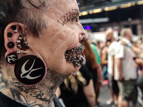 Rolf Buchholz, the world's most pierced man, attends a tattoo convention in Berlin on August 2, 2014.   AFP PHOTO / DPA / PAUL ZINKEN