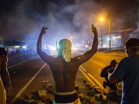 Demonstrators face off with police after tear gas was fired at protesters reacting to the shooting of Michael Brown in Ferguson, Missouri August 17,  2014.  REUTERS/Lucas Jackson