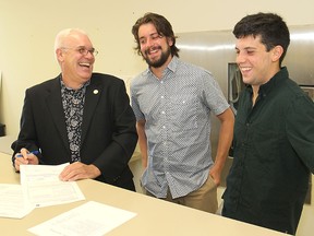 Rick Downes, left, laughs with his sons Patrick, centre, and David as he files his papers at City Hall Monday morning to run for the office of mayor. (Michael Lea/The Whig-Standard)
