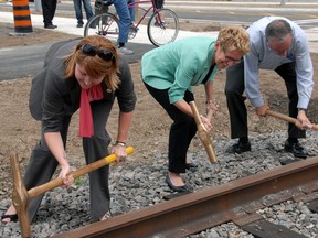 St. Thomas Mayor Heather Jackson, left, Premier Kathleen Wynne and Jeff Leal, Minister of Agriculture, Food and Rural Affairs drive home railway spikes Monday in St. Thomas to complete the Ross St. subway replacement project. The Premier used the occasion to announce the launch of a $100 million per year infrastructure fund available to smaller and rural communities.  (Ian McCallum/Times-Journal)