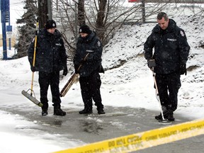 FILE: Edmonton Police Service members search the scene of an officer involved shooting on 118 Ave., and Wayne Gretzky Drive in Edmonton, Alta., on Feb 5, 2011. Cyrus Green, 17, died in the incident. Perry Mah/Edmonton Sun