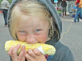 Ellie MacArthur digs her teeth into a cob of corn during the BIA Corn Daze in downtown Mitchell on Saturday, Aug. 16.  KRISTINE JEAN/MITCHELL ADVOCATE