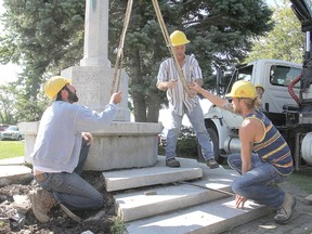 Bill Anderson, centre, directs the work as his crew begins the repair and restoration of the Cross of Sacrifice Monday morning. The steps around the monument have been damaged by the elements. (Michael Lea/The Whig-Standard)