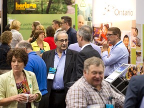 Delegates from municipalities across Ontario mingle with exhibitors displaying products they believe could benefit their towns at the 2014 Association of Municipalities Ontario conference at the London Convention Centre in London, Ontario on Monday August 18, 2014. (CRAIG GLOVER, The London Free Press)