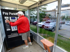 Larry Simpson pays for parking at Victoria Hospital on Monday August 18, 2014 (MORRIS LAMONT, The London Free Press)