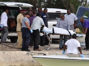 Rescue workers carry from a boat to a hearse the body of one of the victims of a small plane that crashed near the airport of Grand Bahama Island, in East Grand Bahama August 18, 2014.  REUTERS/Vandyke Hepburn