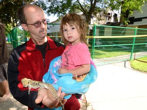 Stephen Simmonds and his daughter Emily care for a lizard rescued from last weekend?s Southdale Rd. townhouse blast. Simmonds has a townhouse in the same complex. (MORRIS LAMONT, The London Free Press)