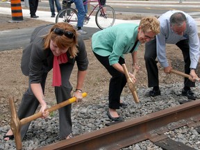 St. Thomas Mayor Heather Jackson, left, Premier Kathleen Wynne and Jeff Leal, Minister of Agriculture, Food and Rural Affairs drive home railway spikes Monday in St. Thomas to complete the Ross St. subway replacement project. The Premier used the occasion to announce the launch of a $100 million per year infrastructure fund available to smaller and rural communities. (Ian McCallum/QMI Agency)