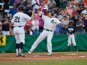 London Majors player Paul Young, right, high fives fellow Majors player Byron Reichstein at home plate after hitting a two-run homer during the first inning of game 7 in their IBL semi-final game against the Kitchener Panthers at Labatt Memorial Park in London, Ontario on Monday August 18, 2014. (CRAIG GLOVER/The London Free Press/QMI Agency)