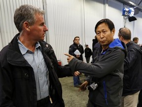 Li Xue Jiang of the Chinese newspaper People's Daily is hauled away by members of the Royal Canadian Mounted Police after he tried to grab a microphone and ask Canadian Prime Minister Stephen Harper (not pictured) a question during a news conference at Xstrata Nickel's Raglan Mine in the Nunavik region of northern Quebec, August 23, 2013. (REUTERS/Chris Wattie)