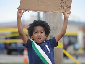 A child participates in a peaceful protest on West Florissant Ave. in Ferguson, Missouri on August 19, 2014. (AFP)