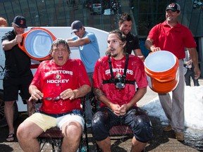Ottawa Senators owner Eugene Melnyk and defenceman Erik Karlsson react after getting drenched with ice water after accepting the ALS Ice Bucket Challenge outside of Canadian Tire Centre on Tuesday. Errol McGihon/Ottawa Sun
