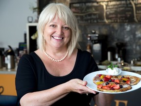 Barbara Cycz presents a plate full of apple pancakes at her Unique Food Attitudes Restaurant and takeout on Dundas St. (DEREK RUTTAN, The London Free Press)