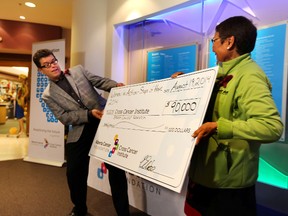 Edna Elias, right, presents a cheque to Dr. John Mackey, director of Clinical Research at the Cross Cancer Clinic, on Tuesday. Elias was part of a group of women who walked from Rankin Inlet to Whale Cove, Nunavut to raise $90,000 for breast cancer research. (PERRY MAH/EDMONTON SUN)