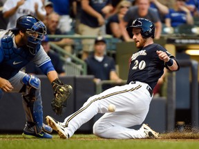 Brewers catcher Jonathan Lucroy (right) scores on a double by third baseman Aramis Ramirez in the first inning as Blue Jays catcher Dioner Navarro (left) fields the ball during MLB Interleague action in Milwaukee on Tuesday, Aug. 19, 2014. (Benny Sieu/USA TODAY Sports)