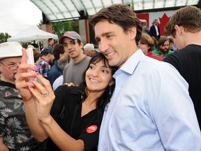 Liberal leader Justin Trudeau poses for a selfie with a supporter following a rally in Edmonton on Tuesday. ( REUTERS/Dan Riedlhuber)