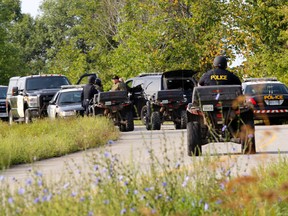 An OPP tactical search team assembles with ATVs on Howe Road in Lyn, Ont., northwest of Brockville, Ont. Wednesday morning, Aug. 20, 2014. Police were searching the area for missing Recorder and Times sports editor Steve Pettibone. (DARCY CHEEK/The Recorder and Times).