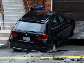A sinkhole in the driveway of a townhouse on Palmdale Dr., near Sheppard and Warden Aves, nearly swallowed a BMW. (Michael Peake/Toronto Sun)