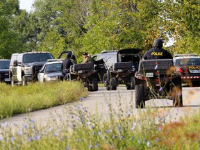 An OPP tactical search team assembles with ATVs on Howe Road, near Brockville, Ont., on Wednesday morning. Police are searching the area for missing Sun Media sports editor Steve Pettibone. (Darcy Cheek/QMI Agency)