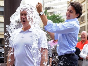 Liberal leader Justin Trudeau (R) dumps a bucket of ice water onto Liberal MP Sean Casey for the ALS Ice Bucket Challenge during a break in the Federal Liberal summer caucus meetings in Edmonton Aug. 19, 2014.  REUTERS/Dan Riedlhube