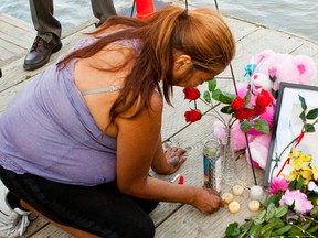 Lana Fontaine, an aunt of Tina Fontaine, lights candles at a memorial set up on the Alexander Docks in Winnpeg, Man., on Tues., Aug. 19, 2014. Hundreds of people gathered to honour the memory of Tina fontaine and Faron Hall. There bodies were found in two separate recoveries on Sun., Aug. 17, 2014. (Brook Jones/QMI Agency)