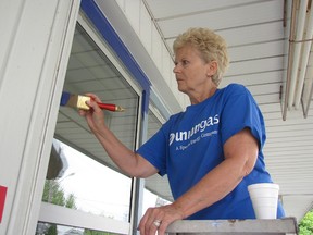 Dianne Jackson paints the trim of the St. Vincent de Paul Thrift Store on King St. E. on Aug.20. Jackson and other members of the Union Gas retiree group, the Golden Genies, donated their time to spruce up the building while materials were donated through the company's Helping Hands Project.