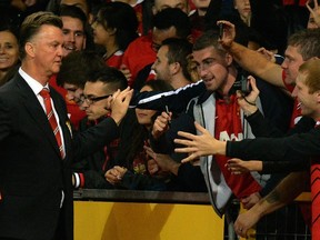 Manchester United manager Louis Van Gaal signs autographs after the pre-season football friendly match between his club and Valencia at Old Trafford on August 12, 2014. (AFP PHOTO/PAUL ELLIS)
