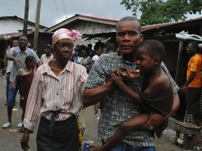 Residents flee during clashes in the West Point quarantined neighbourhood of Liberia's capital Monrovia, August 20, 2014. Police in the Liberian capital Monrovia fired tear gas on Wednesday to disperse a stone-throwing crowd agitating to leave the neighbourhood placed under quarantine because of the Ebola virus. REUTERS/James Harding Giahyue