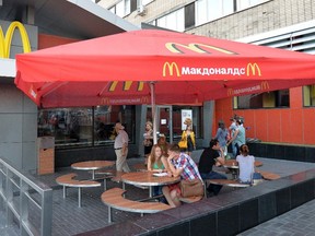 People sit outside a closed McDonald's restaurant in Moscow, August 20, 2014. (REUTERS/Tatyana Makeyeva)