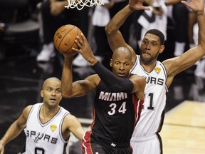 Miami Heat's Ray Allen (C) looks to pass under pressure from San Antonio Spurs' Tim Duncan (R) and Tony Parker of France during the second half in Game 5 of their NBA Finals basketball series in San Antonio, Texas, June 15, 2014. (REUTERS/Mike Stone)