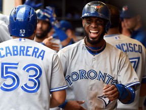 Blue Jays shortstop Jose Reyes (right) smiles in the dugout after scoring in the sixth inning against the Brewers in Milwaukee on Wednesday, Aug. 20, 2014. (Benny Sieu/USA TODAY Sports)