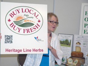 Donna Lunn, coordinator of Elgin county's Buy Local, Buy Fresh program, holds a sign featuring a QR code at an event Wednesday that launched the program's new website. (Ben Forrest, Times-Journal)