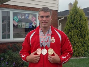 Noah Rolph stands outside his St. Thomas home with medals he won at the recent Legion National Youth Track and Field Championships in Langley, B.C. Rolph won gold in hammer throw, silver in shot put and bronze in discus at the meet. (Ben Forrest, Times-Journal)
