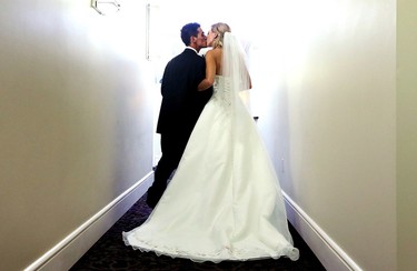 A wedding photographer's flash goes off behind them as Josh Melynk kisses his new wife Megan Wolfe, 28, following a ceremony at the Union Bank Inn, 10053 Jasper Ave., in Edmonton Alta., on Wednesday Aug. 20, 2014. Wolfe has stage 4 stomach cancer. The couple turned to crowdfunding to make the wedding a reality. The couple has two year-old twin boys. Wolfe also has two other sons aged 6 and 7. Melynk also has an eleven year-old daughter. David Bloom/Edmonton Sun/QMI Agency