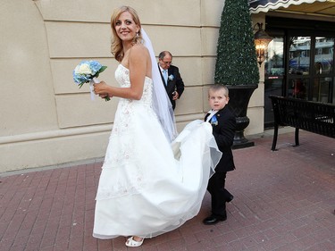 Hayden Wolfe, 6, helps carry his mother Megan Wolfe's, 28, wedding gown, following her wedding to Josh Melynk, at the Union Bank Inn, 10053 Jasper Ave., in Edmonton Alta., on Wednesday Aug. 20, 2014. Wolfe has stage 4 stomach cancer. The couple turned to crowdfunding to make the wedding a reality. The couple has two year-old twin boys. Wolfe also has two other sons aged 6 and 7. Melynk also has an eleven year-old daughter. David Bloom/Edmonton Sun/QMI Agency