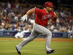 Albert Pujols of the Los Angeles Angels of Anaheim takes off running after hitting a RBI double in the third inning against the Los Angeles Dodgers at Dodger Stadium on August 5, 2014. (Lisa Blumenfeld/Getty Images/AFP)