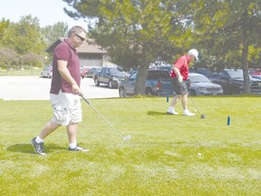 Huron County warden, Joe Steffler, and his son, John, practice their swings at the first hole.