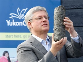 Prime Minister Stephen Harper looks at a permafrost core sample during a photo opportunity at Yukon College in Whitehorse, Yukon on August 21, 2014. (REUTERS/Chris Wattie)