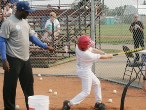 Ex-Toronto Blue Jay, and World Series champ, Devon White, gives some hitting tips to a young ball player during the Jays Super Camp, held at Henry Singer Park in the Grove on Aug. 14. White was one of four former Jays on hand for the clinic to help kids improve their skills. - Gord Montgomery, Reporter/Examiner
