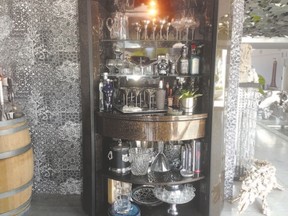 Ensure the colours and textures you use in one space flow to the next. The glass beaded paper behind this kitchen bar cabinet ties into the granite walls of the adjoining living room.