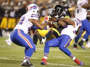 Steelers receiver Darrius Heyward-Bey (centre) is tackled after catching a pass by Bills inside linebacker Preston Brown (52) and cornerback Ron Brooks (right) during NFL pre-season action in Pittsburgh on Aug. 16, 2014. (Charles LeClaire/USA TODAY Sports)