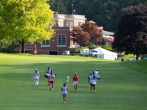 The clubhouse sits in the distance as a group of golfers walk down the ninth fairway during the second round of the Canadian Pacific Women?s Open at the London Hunt and Country Club on Friday. (CRAIG GLOVER, The London Free Press)