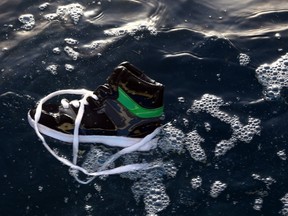 A shoe belonging to an illegal immigrant floats on the water after a boat carrying 200 illegal migrants from sub-Saharan Africa sank off the shores of al-Qarbole, some 60 kilometers east of the Libyan capital Tripoli, on August 22, 2014. AFP PHOTO/MAHMUD TURKIA