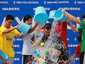 Men dump buckets of ice water and plastic balls onto former NBA player Yao Ming as Yao takes part in the ALS ice bucket challenge in Beijing August 23, 2014. The Ice Bucket Challenge is aimed at raising awareness of - and money to fight - Amyotrophic Lateral Sclerosis, more often known as ALS or Lou Gherig's Disease.  REUTERS/Kim Kyung-Hoon (CHINA - Tags: HEALTH SOCIETY SPORT BASKETBALL TPX IMAGES OF THE DAY)